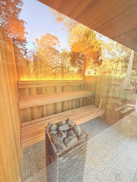 Inside the sauna: cedar benches against a bare brick wall.